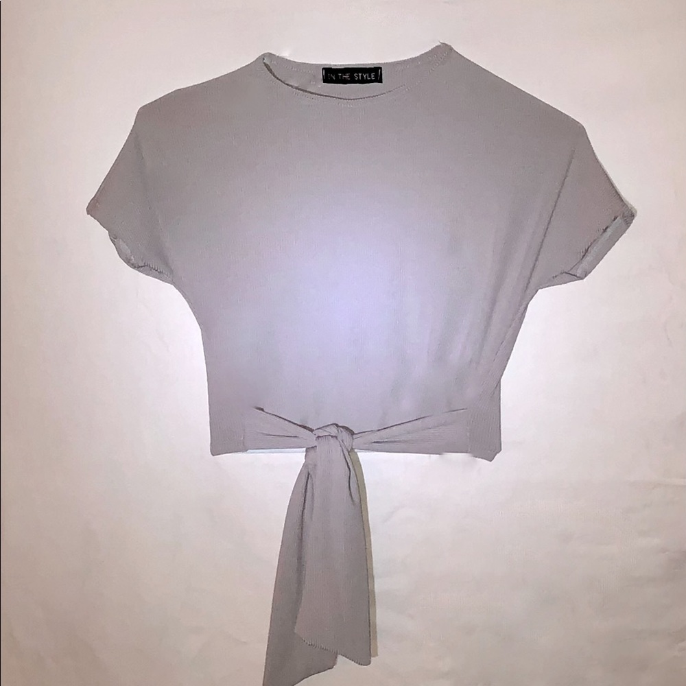 Grey tight fitted short sleeve shirt with cross ties at bottom.